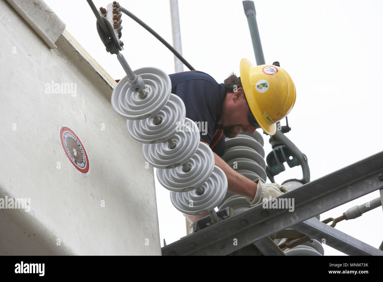 Electric utility bluecollar workman repairing an electric substation