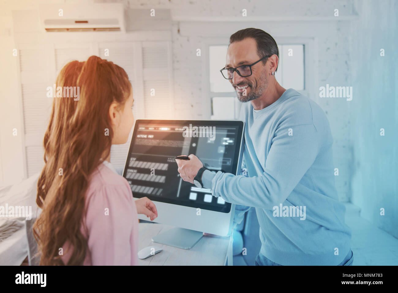 Emotional teacher pointing to the screen and looking attentively at his ...