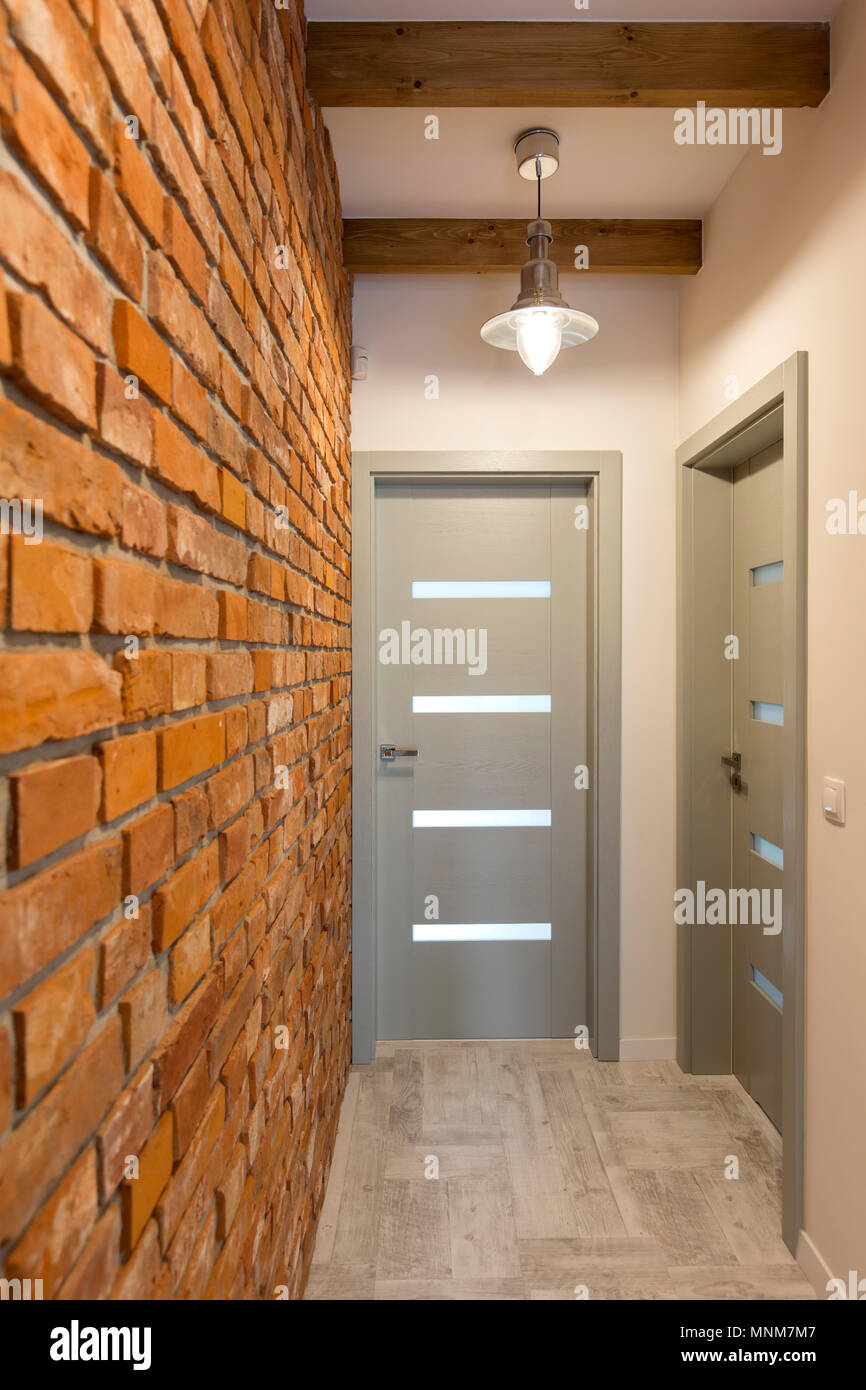 Shot of a corridor with a brick wall and two doors Stock Photo