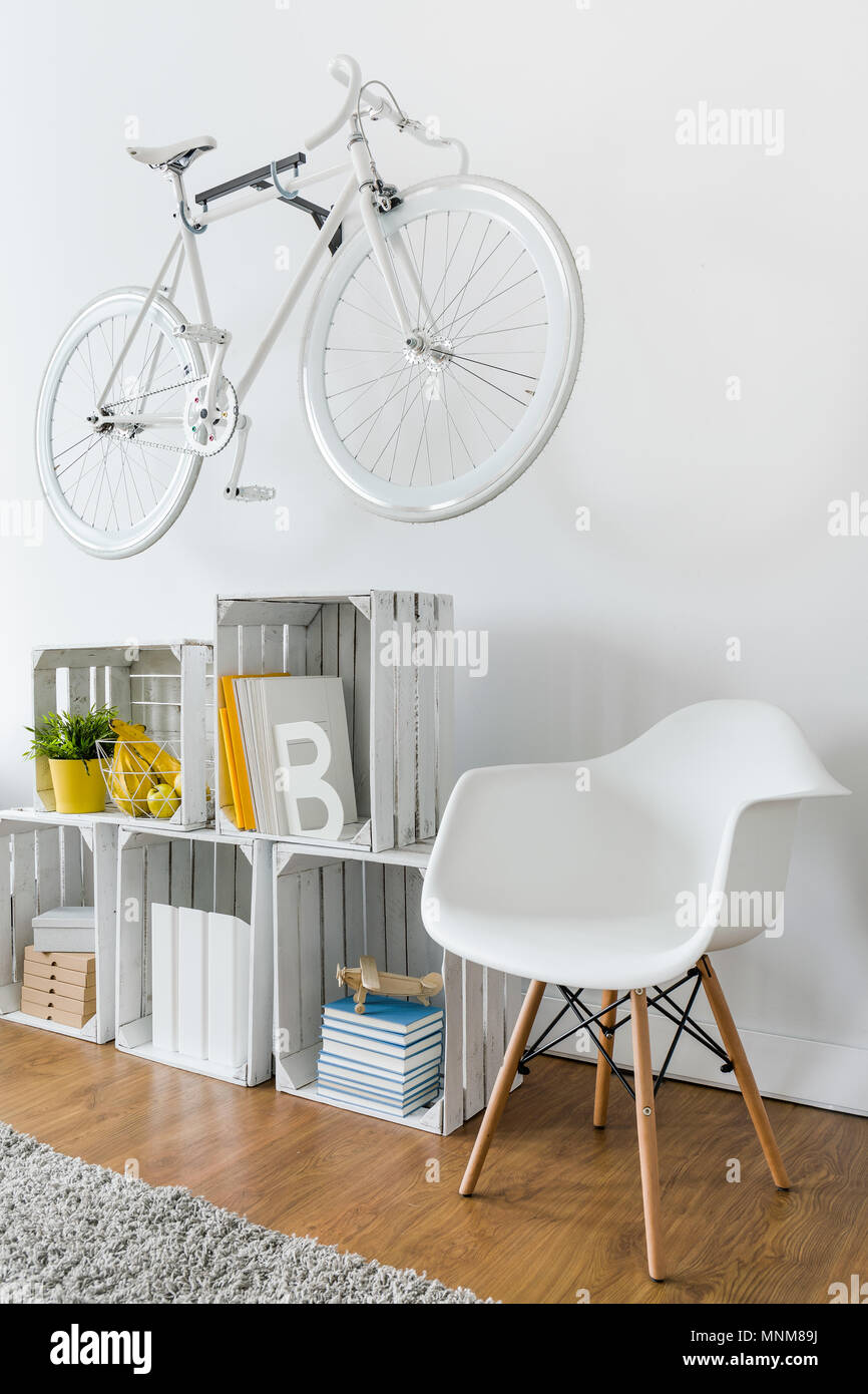 Shelf made from wood box, chair and bike hanging on white wall Stock Photo