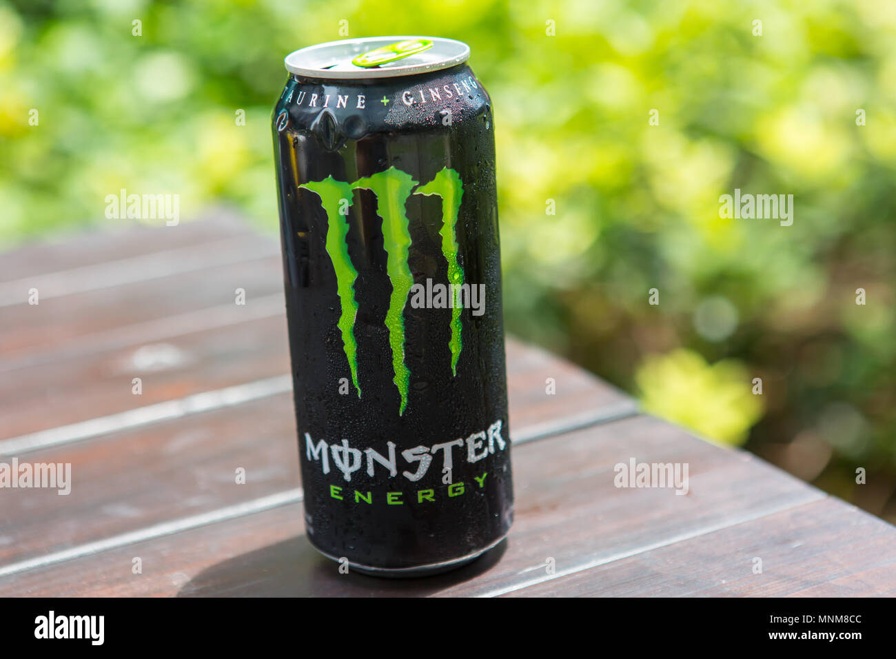 Monster Energy drink on table against a green background. Stock Photo