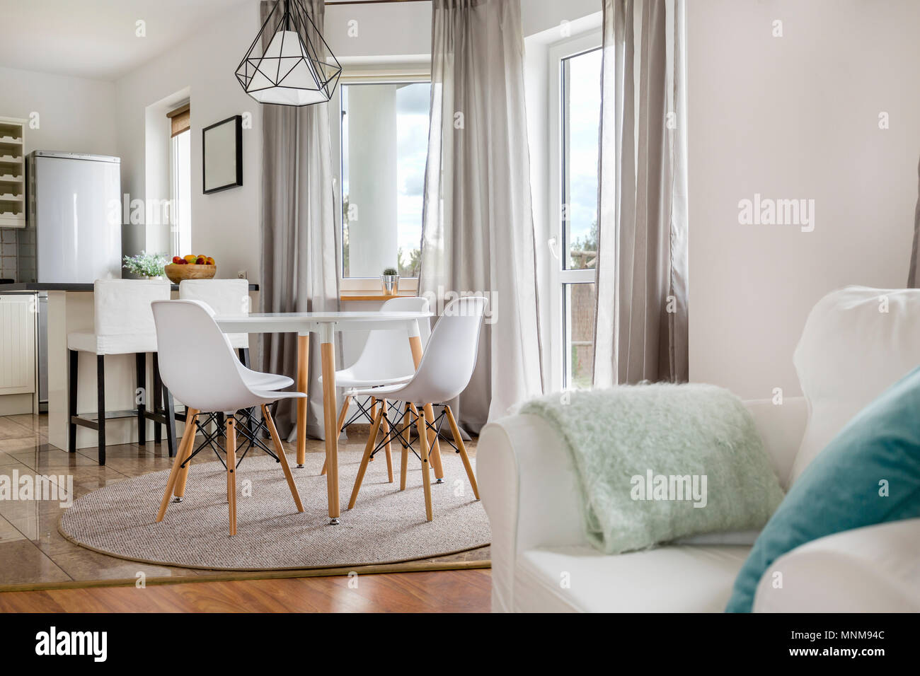 New flat with round table, white chairs and open kitchen Stock Photo