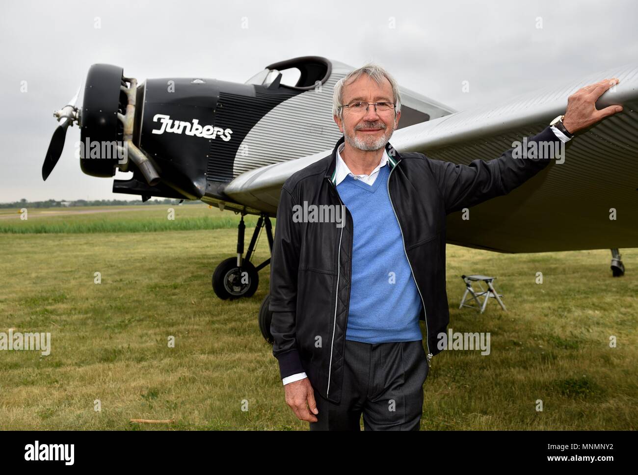 18 May 2018, Germany, Dessau-Rosslau: Bernd Junkers, grandson of Prof. Hugo Junkers, standing beside a replica of a Junkers F 13 which has landed at the airfield during the 13th Hugo Junkers Festival. The replica of one of Prof. Hugo Junkers' most famous creations is the only airworthy example of its kind. It was faithfully built over more than 10 years using original construction plans and laser measurements of museum planes. Photo: Frank May/dpa/ZB Stock Photo