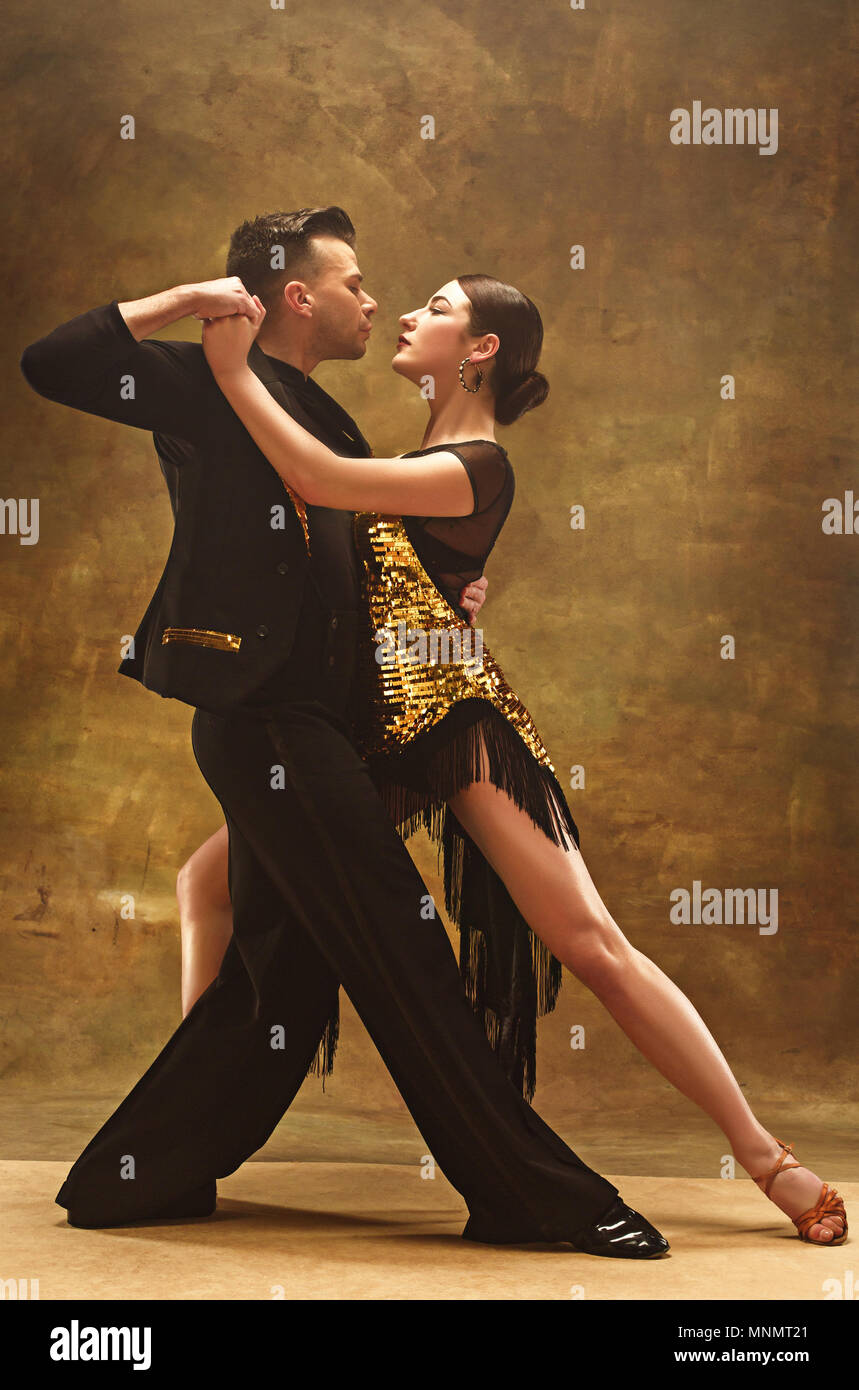 Dance ballroom couple in gold dress dancing on studio background Stock  Photo - Alamy