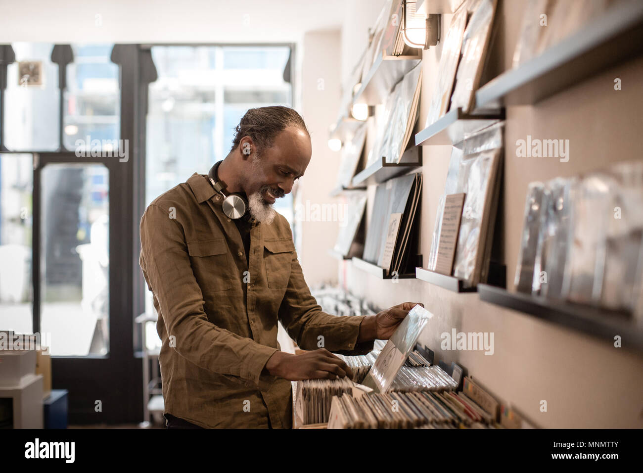 Senior Male looking for records in a store Stock Photo