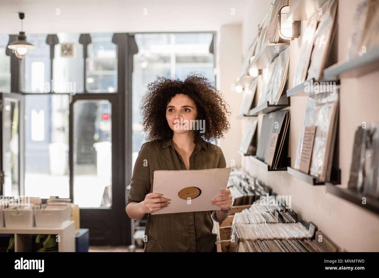 Young Adult female holding record in a store Stock Photo