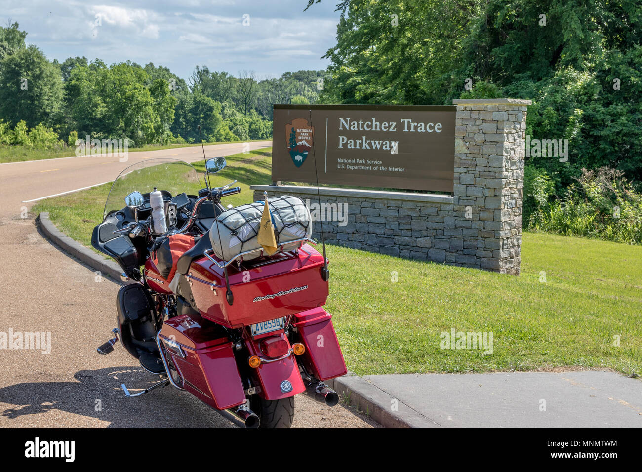 A motorcycle with camping gear strapped on, setting at the southern entrance to the Natchez Trace Parkway, in Mississippi, USA. Stock Photo