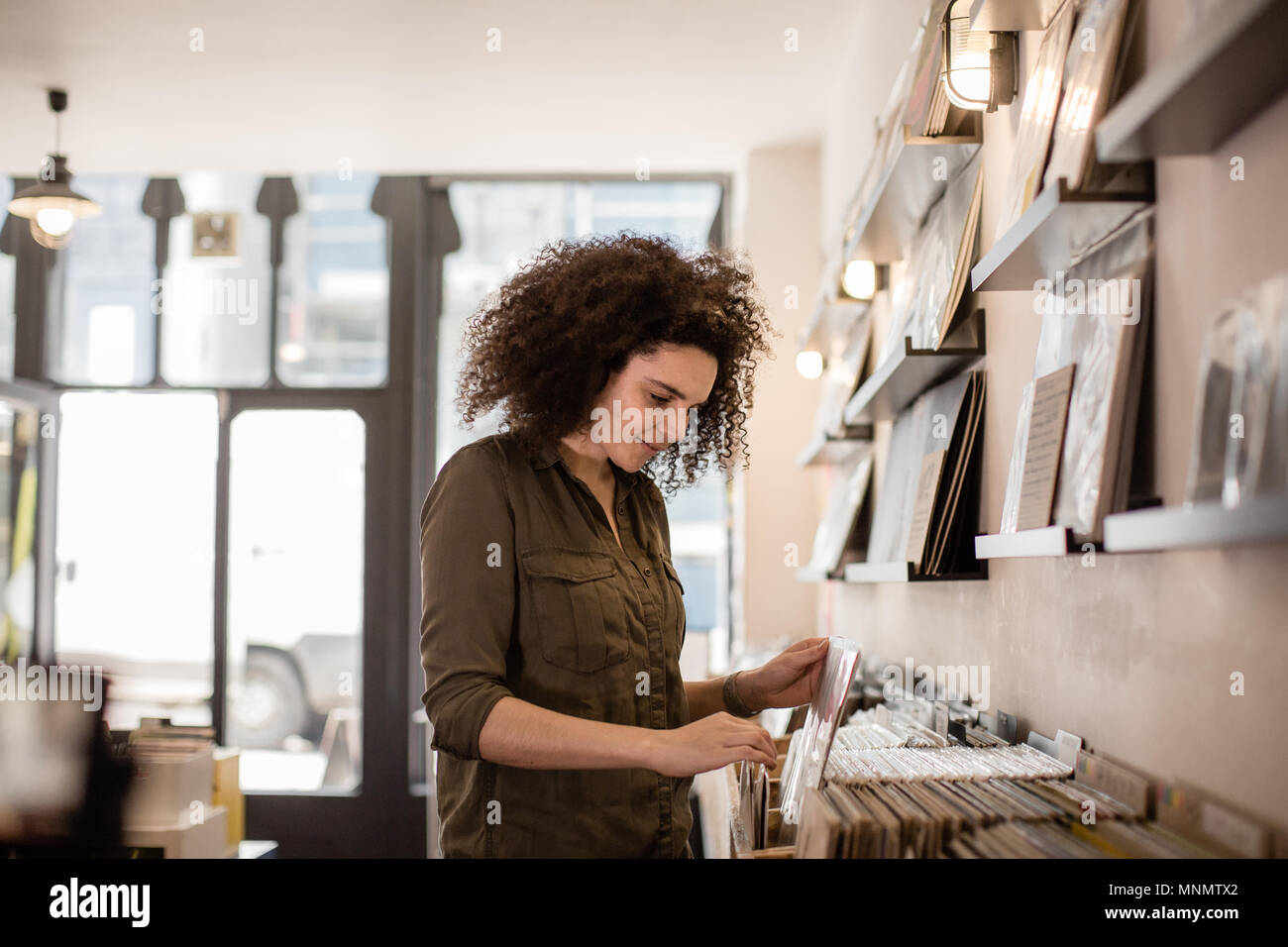 Young adult female looking for records in a store Stock Photo