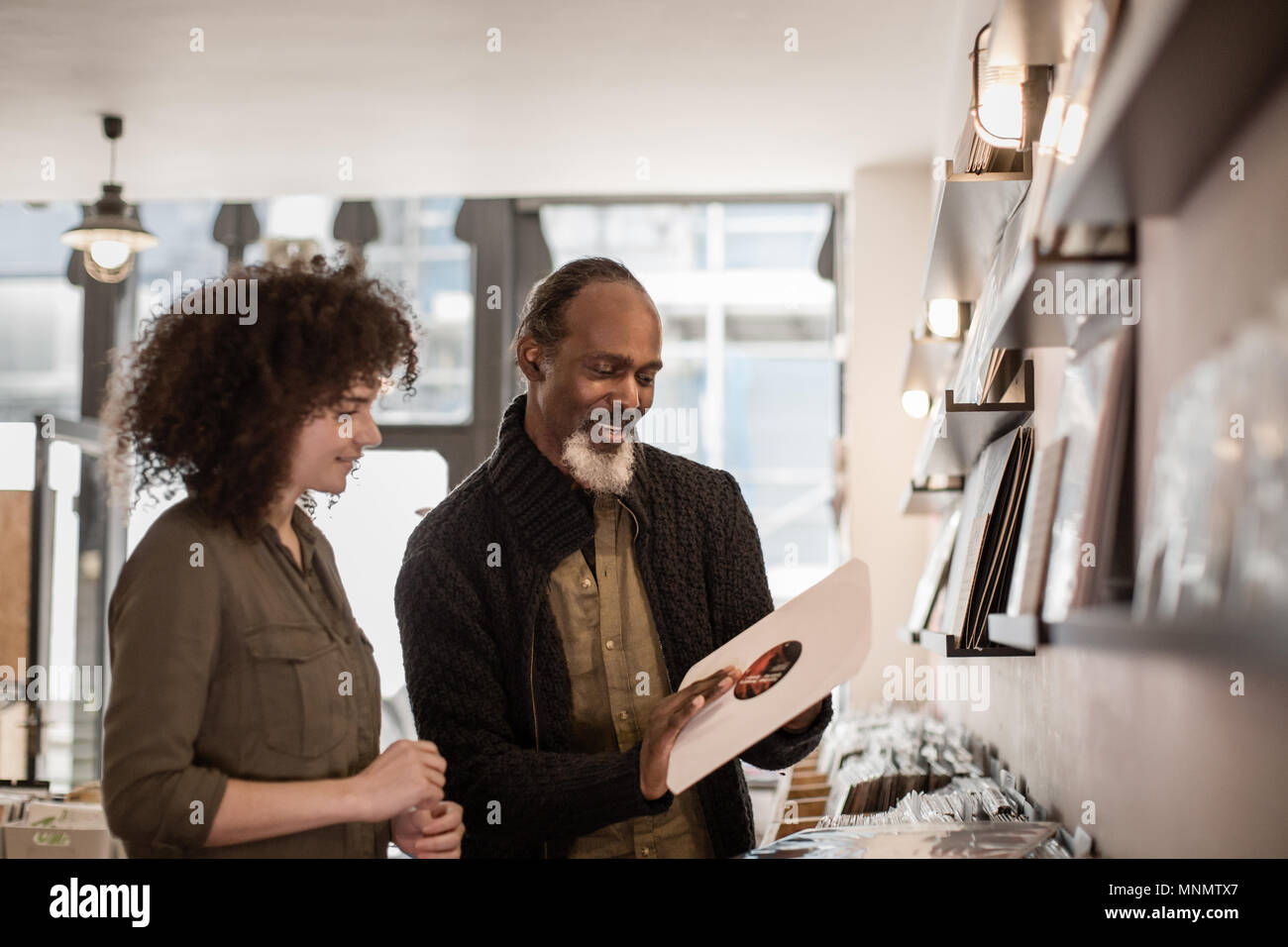 Store owner helping customer in a record store Stock Photo