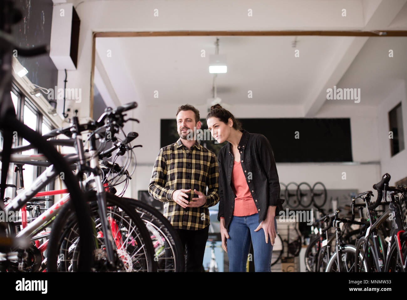 Small business owner serving customer in a bike store Stock Photo