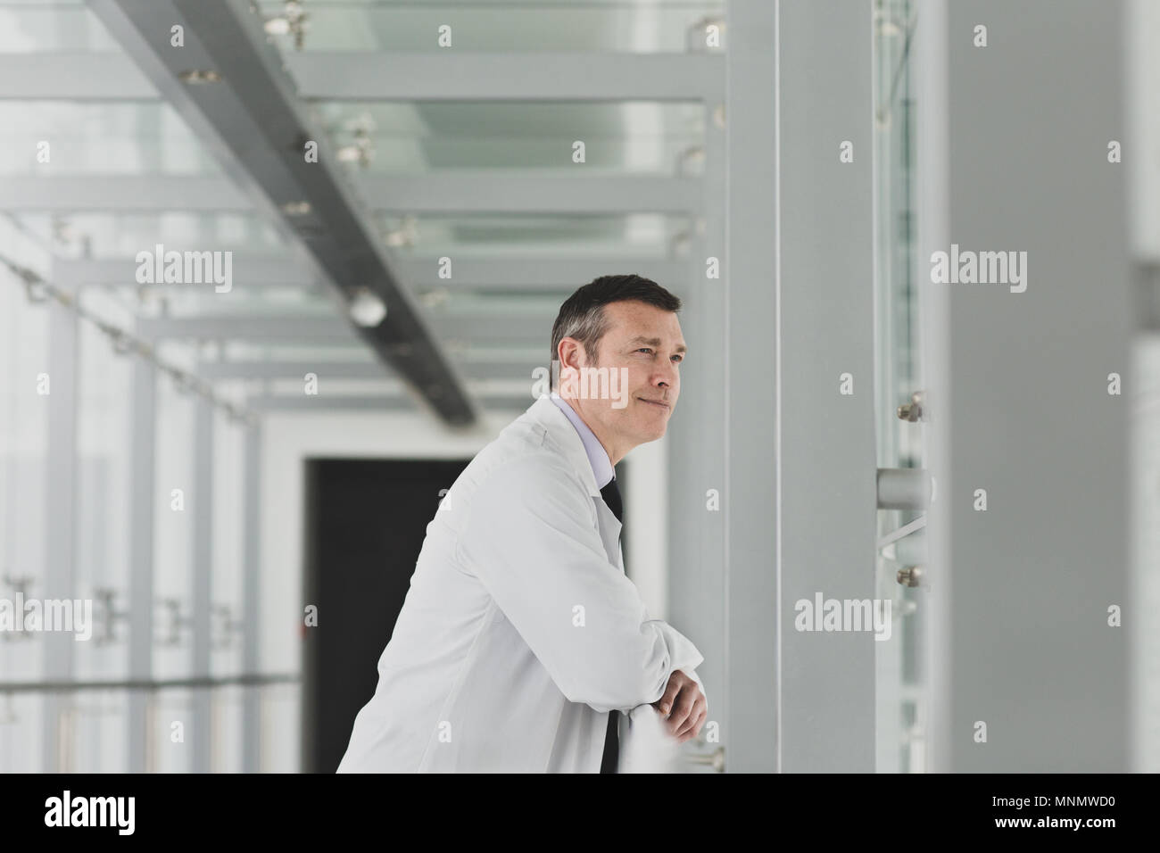 Healthcare professional looking out of window in a modern hospital Stock Photo