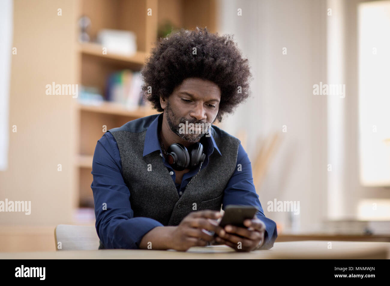 Businessman using smartphone at desk Stock Photo