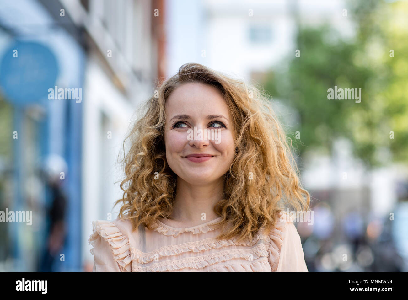 Adult female thinking outdoors in city Stock Photo