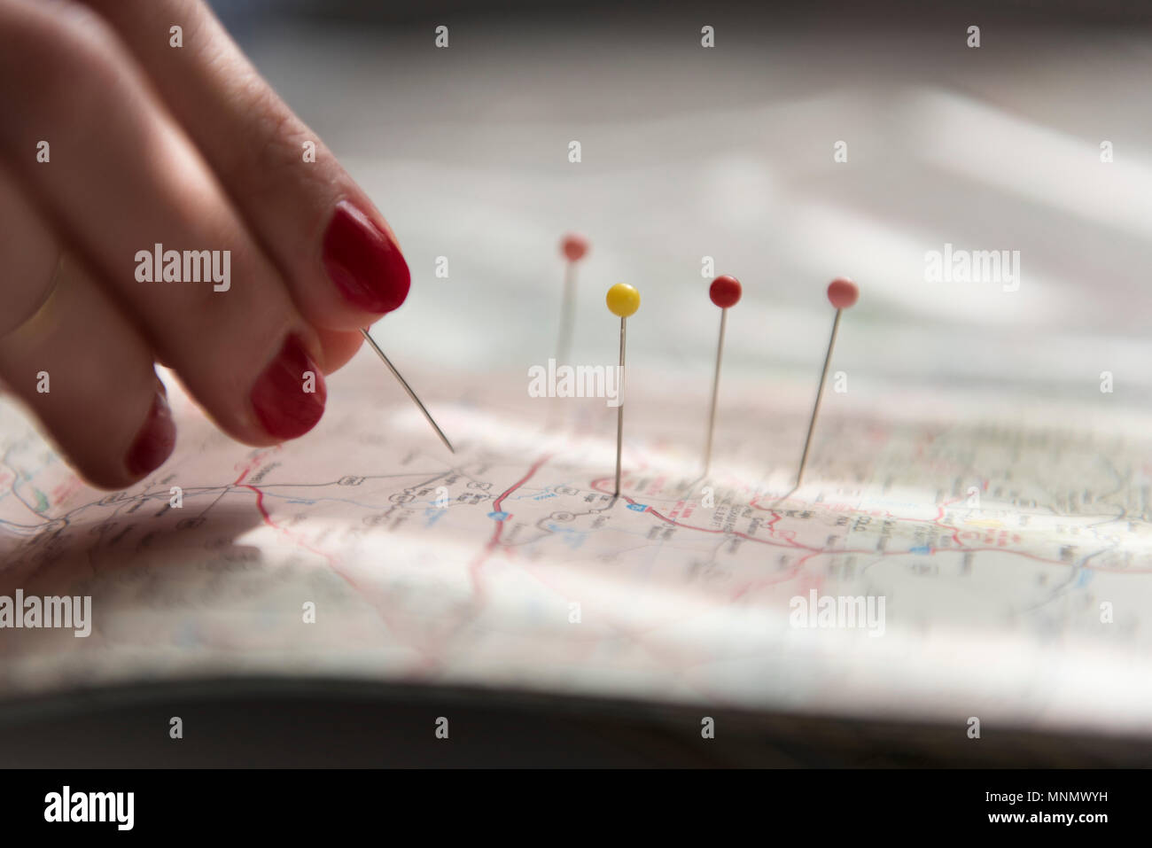 Woman applying pins on map Stock Photo