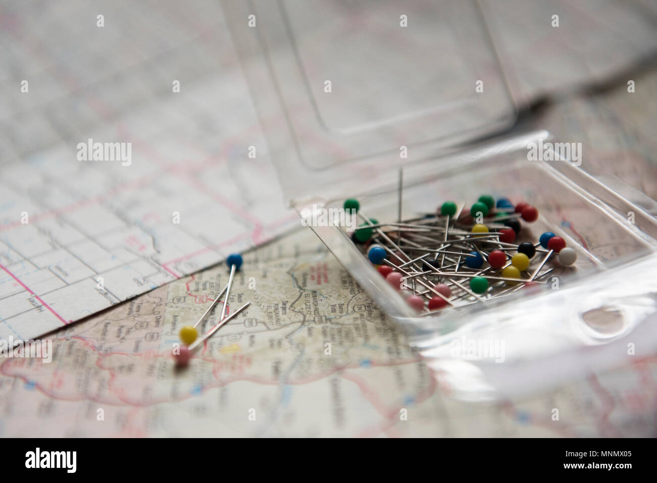 Pins in box lying on map Stock Photo