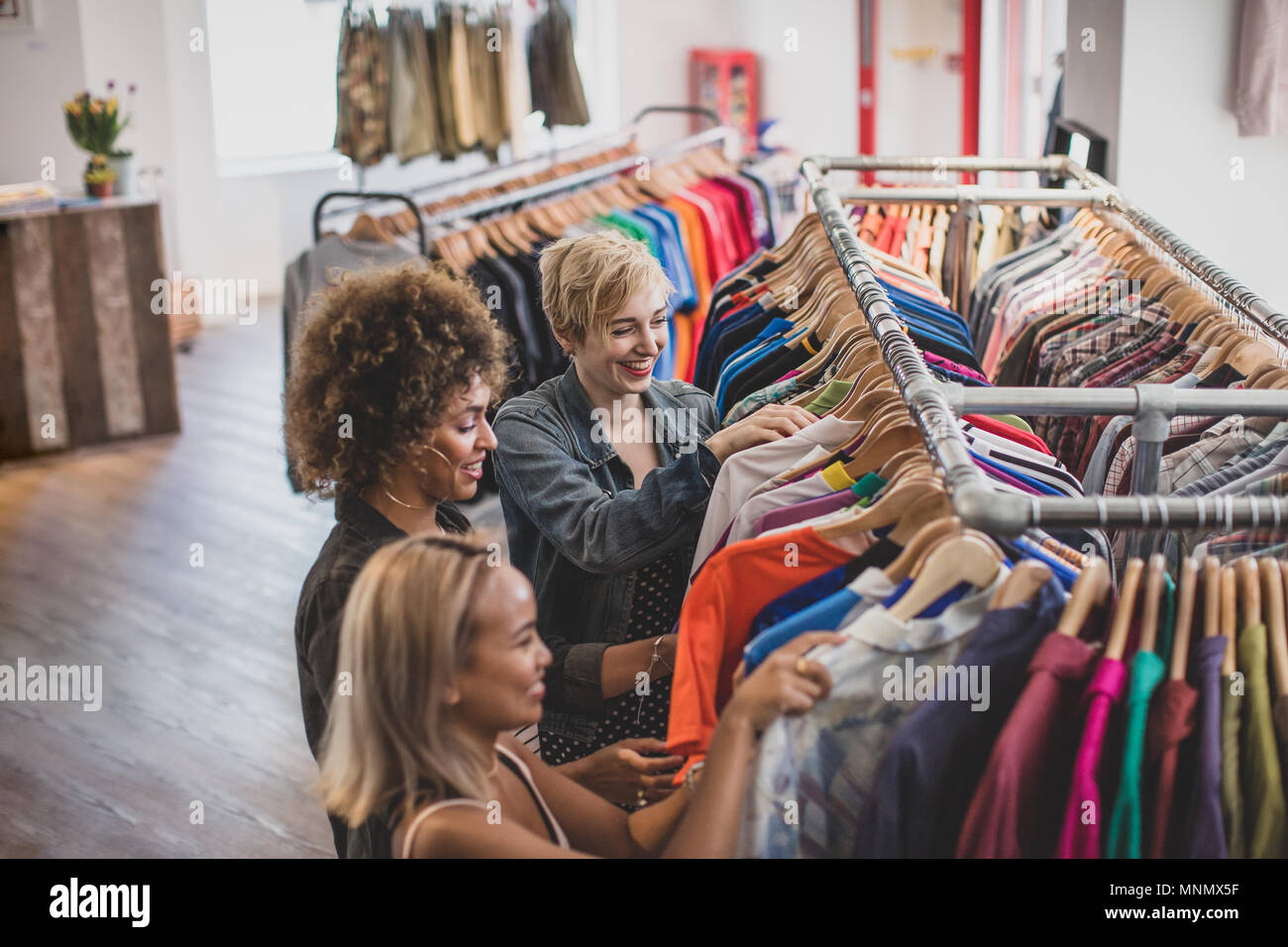 Millennial female friends shopping in a vintage clothing store Stock Photo