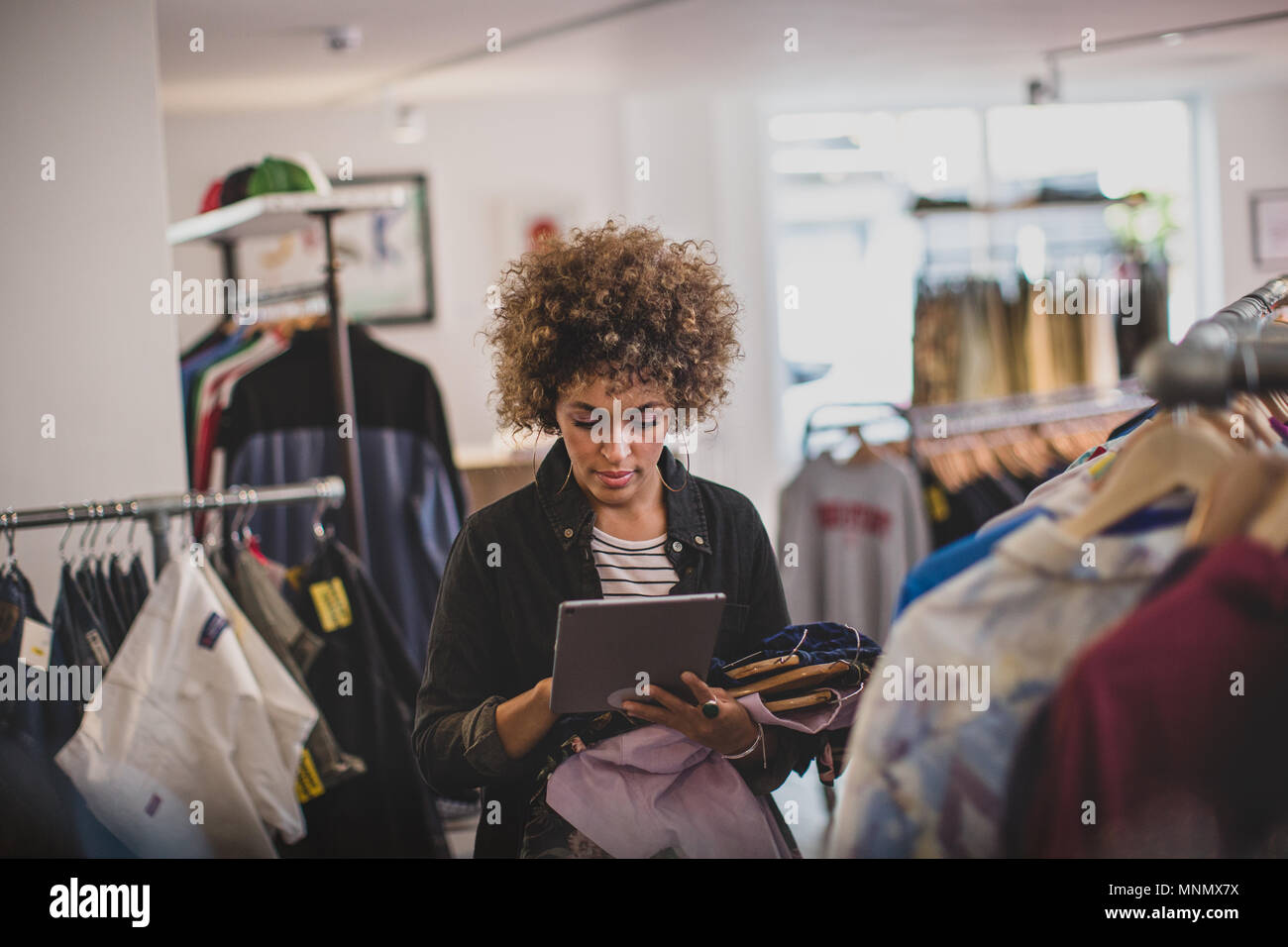 Store manager using digital tablet in a clothing store Stock Photo