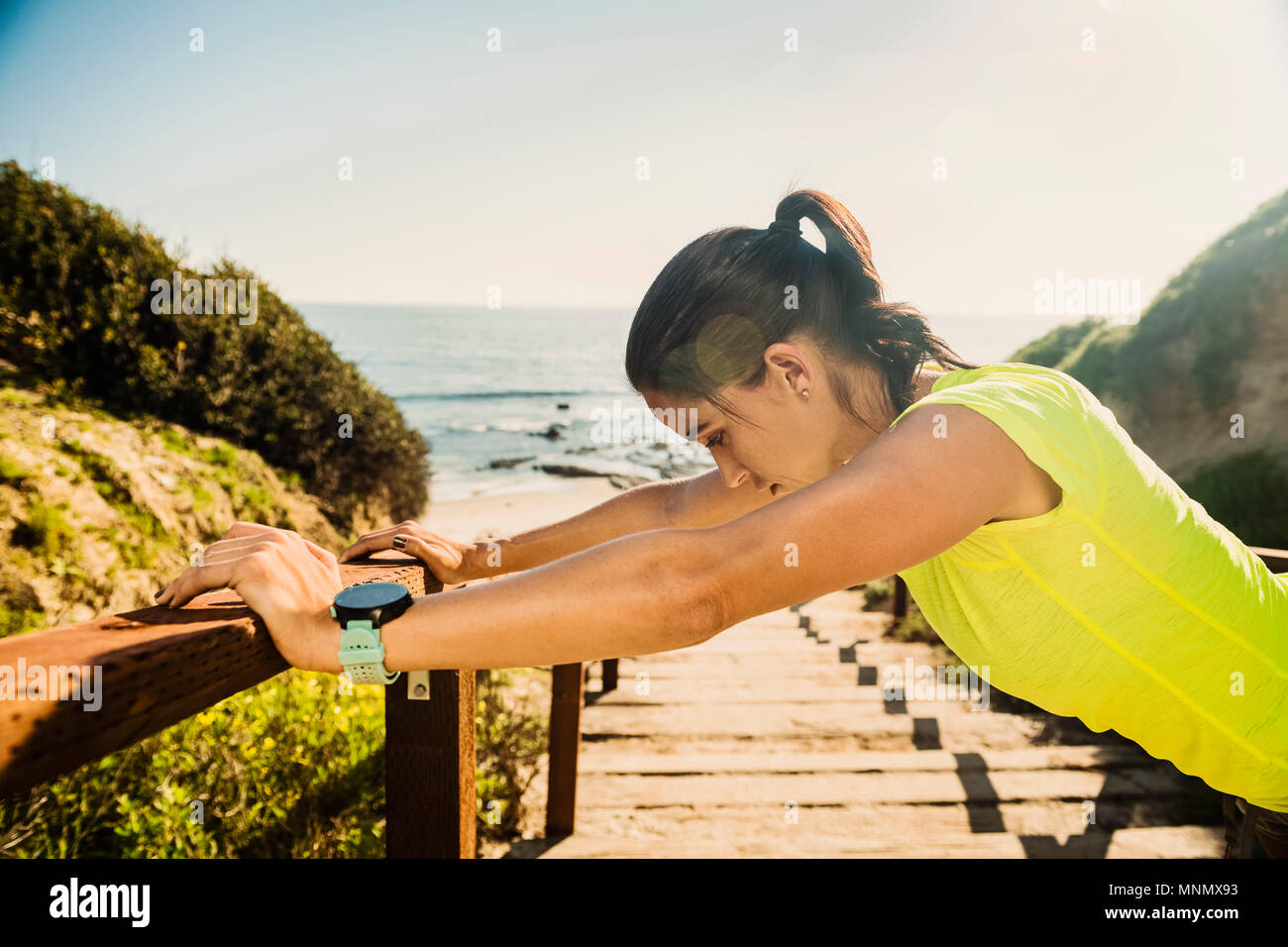 USA, California, Newport Beach, Woman stretching on beach Stock Photo