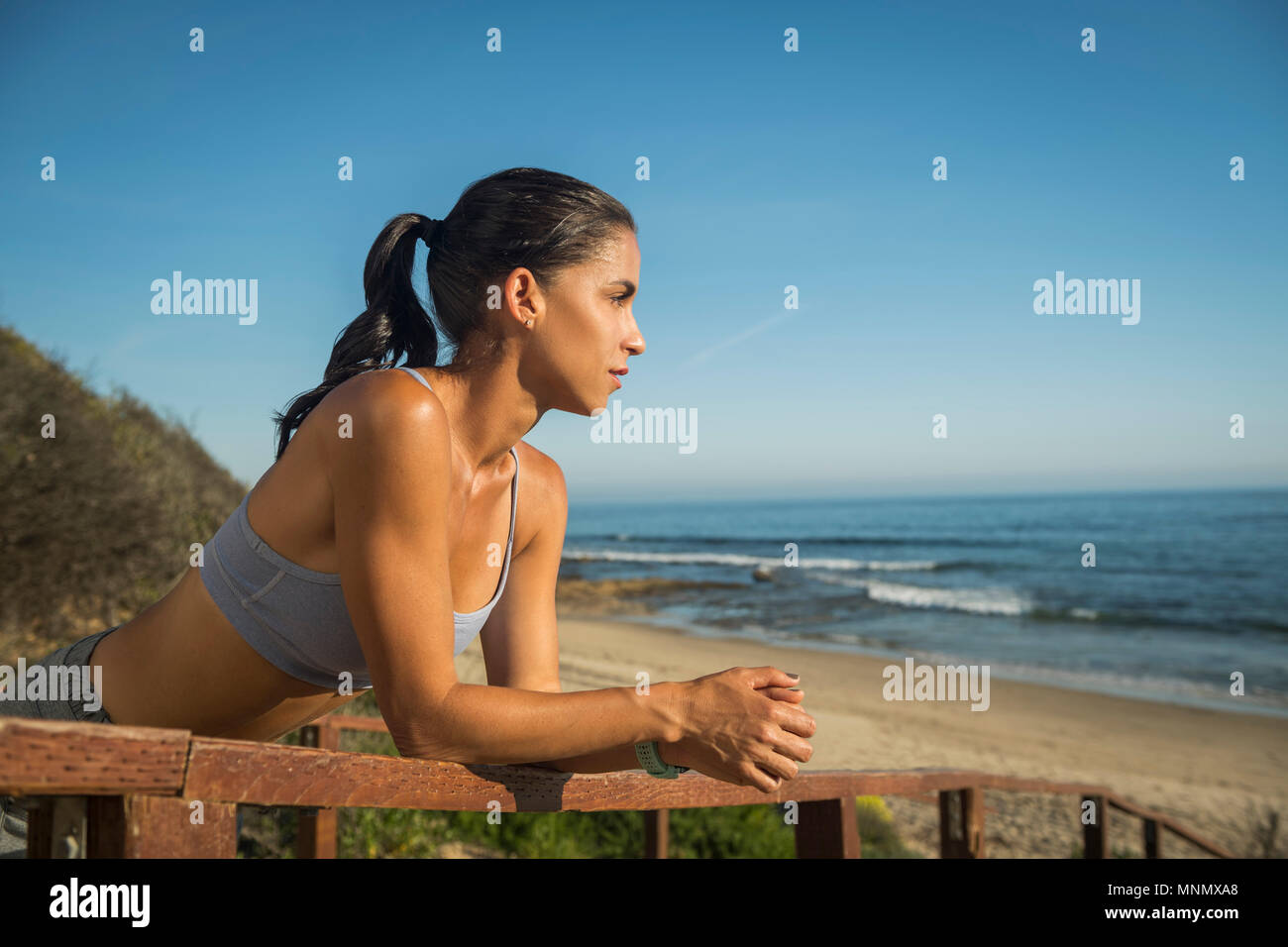 USA, California, Newport Beach, Woman in sport suit looking at sea Stock Photo