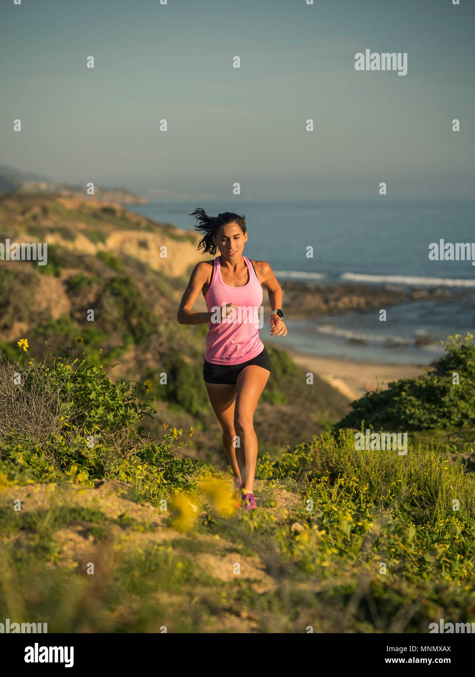 USA, California, Newport Beach, Woman running along cliff Stock Photo