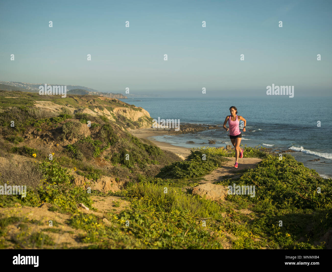 USA, California, Newport Beach, Woman running along cliff Stock Photo