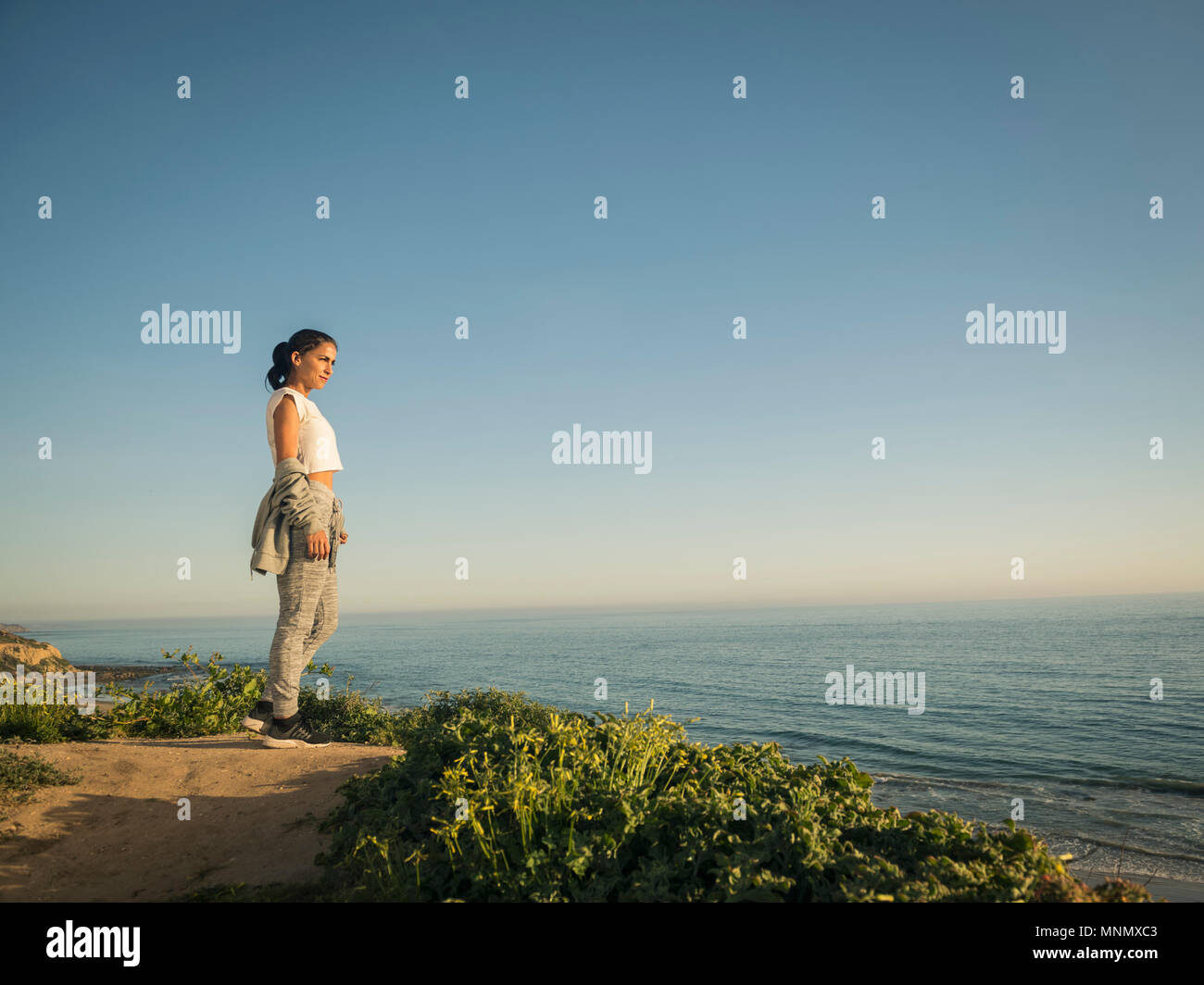 USA, California, Newport Beach, Woman standing on cliff and looking at view Stock Photo