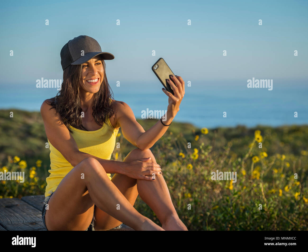 Woman in baseball cap taking selfie Stock Photo