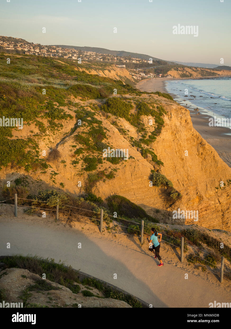 USA, California, Newport Beach, Woman running along footpath Stock Photo