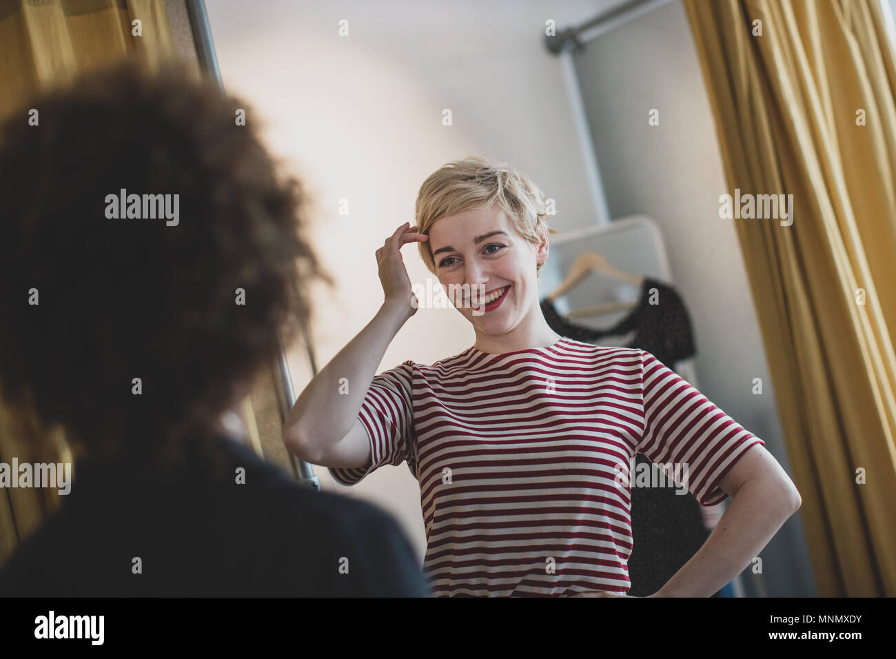 Young adult female trying on clothes in a vintage store Stock Photo