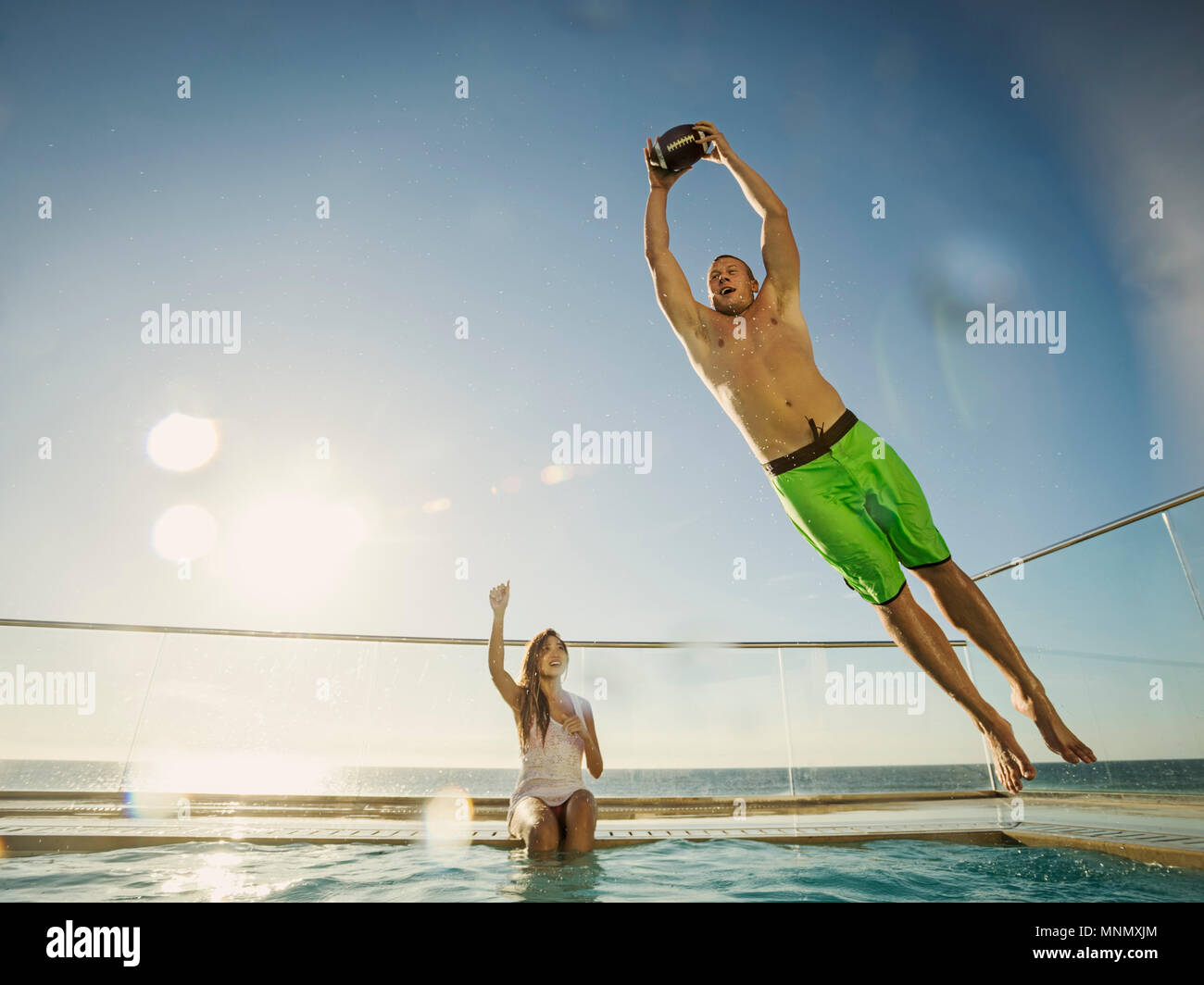 Couple playing football in swimming pool Stock Photo
