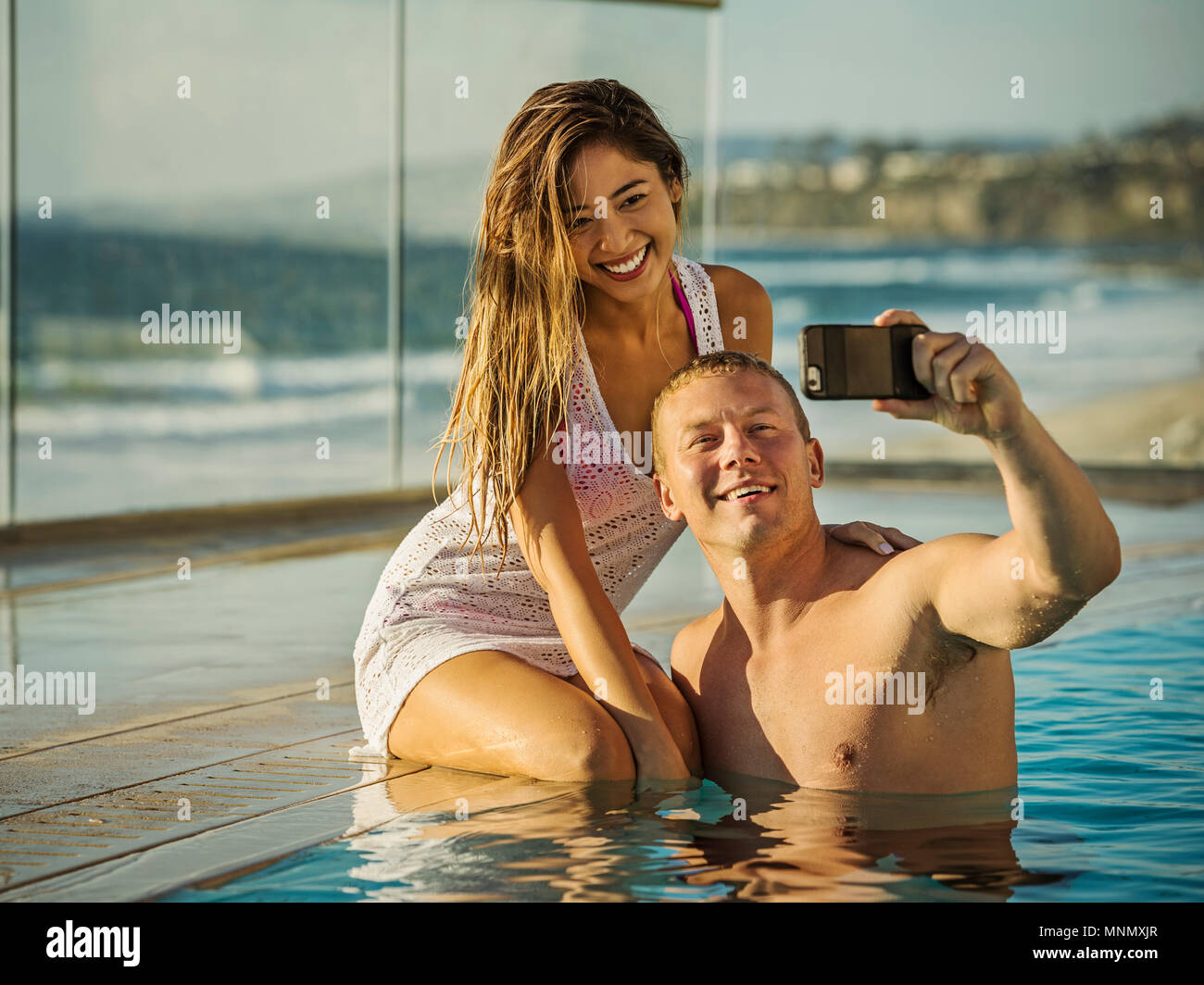Couple taking selfie in swimming pool Stock Photo