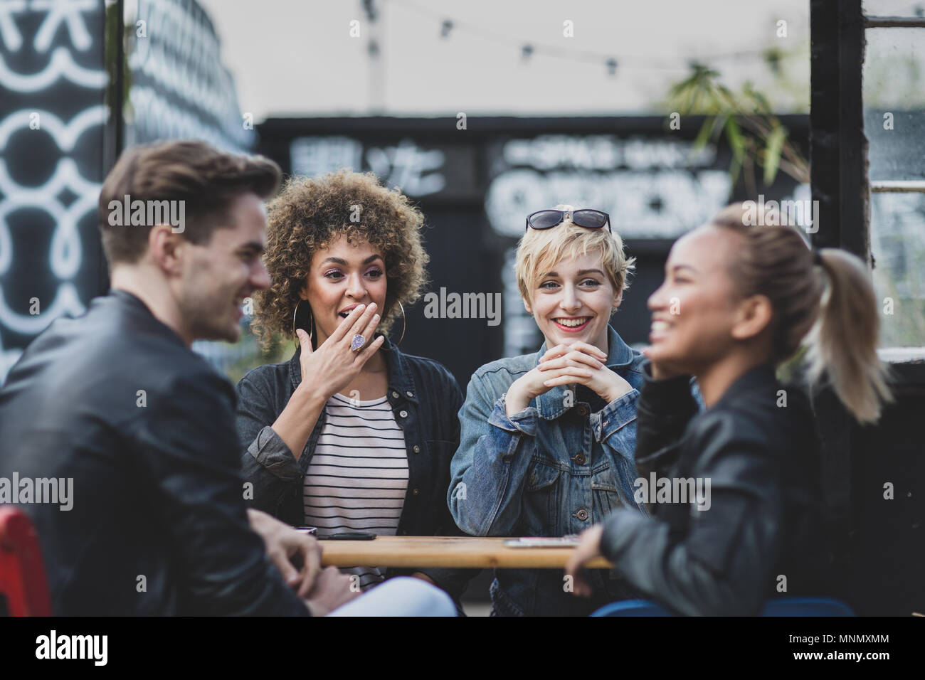 Friends socialising outdoors in summer Stock Photo