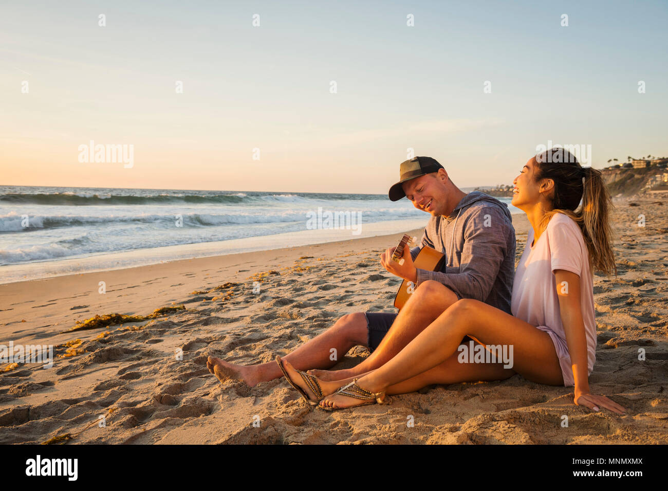 Couple sitting on beach Stock Photo