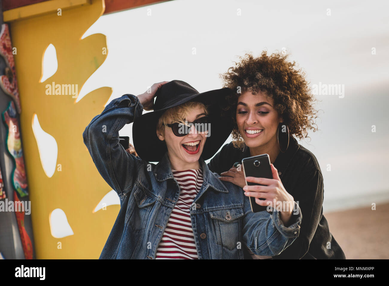 Friends taking selfie on windy beach Stock Photo