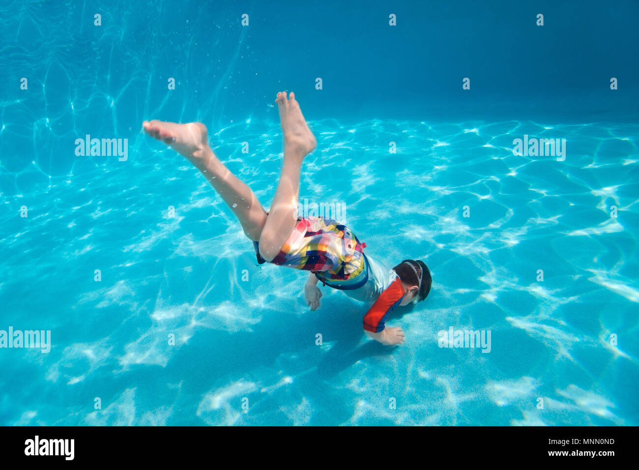 Cute little boy diving underwater in swimming pool, Cute little boy