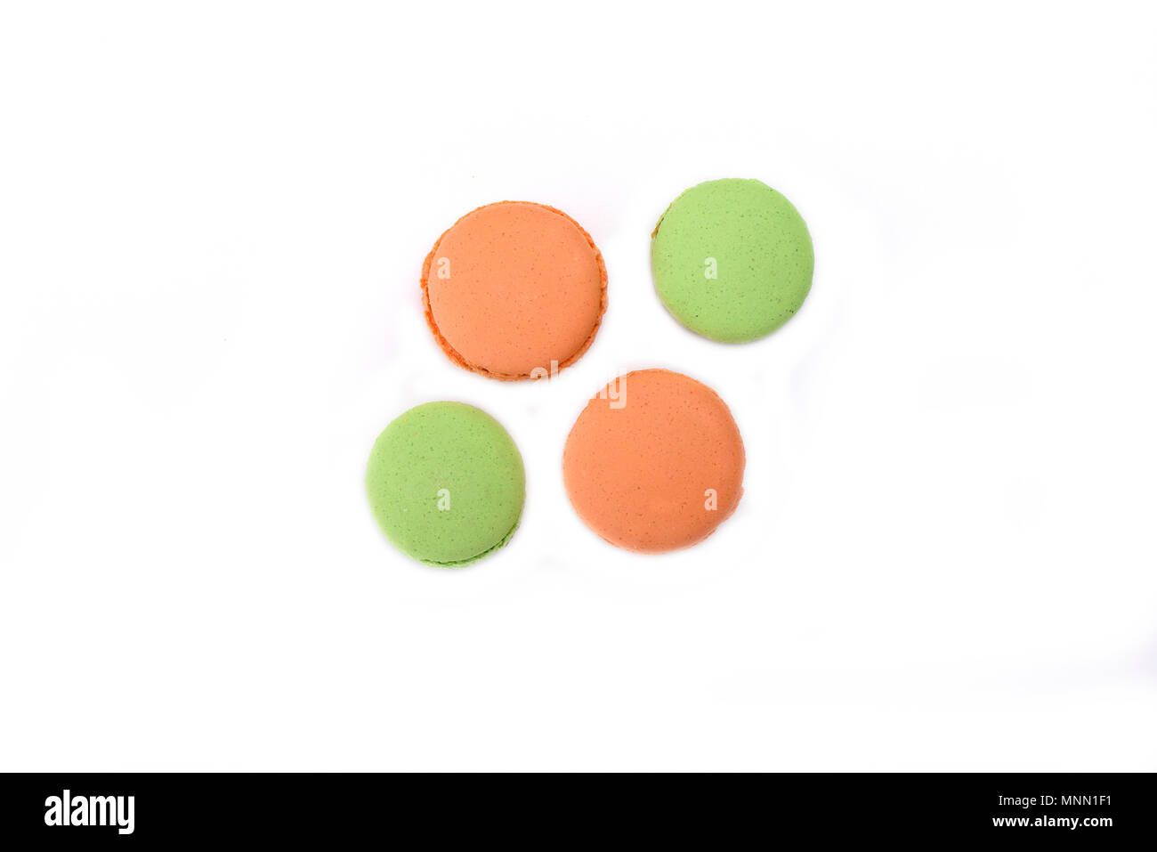 Orange and green macaroons isolated on white background Stock Photo