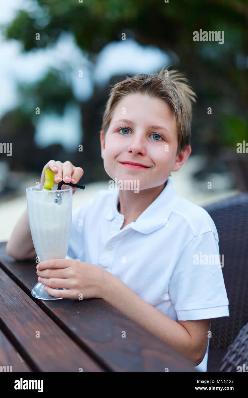 Teenage boy drinking milkshake in outdoor cafe Stock Photo