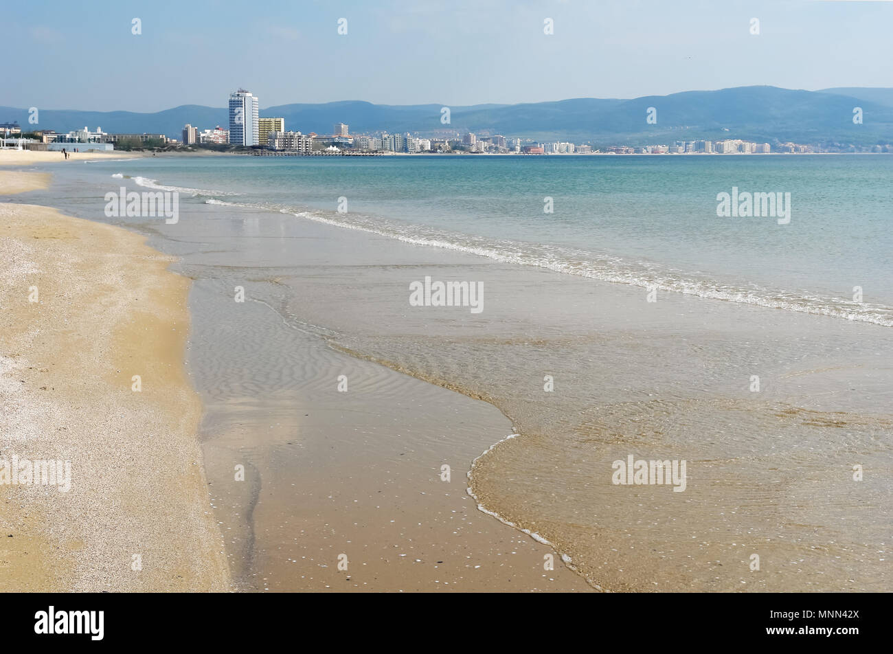 A sandy beach with clear sea water and a panoramic view of the coast of the Bulgarian resort of Sunny Beach. Stock Photo