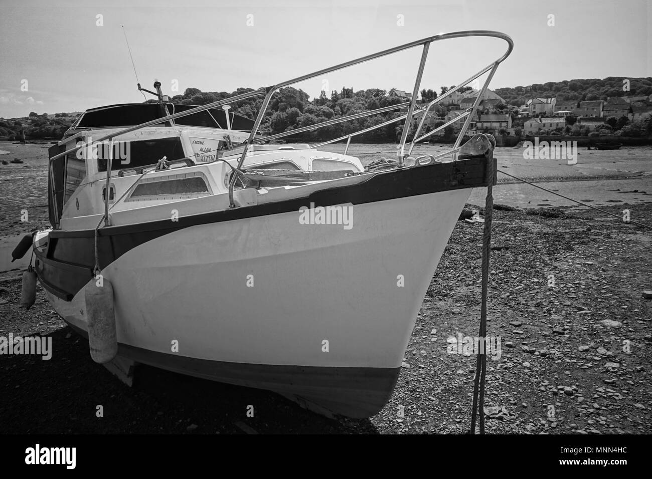 Boat in Plymouth in the sunshine, with the tide out and in black and white. Stock Photo