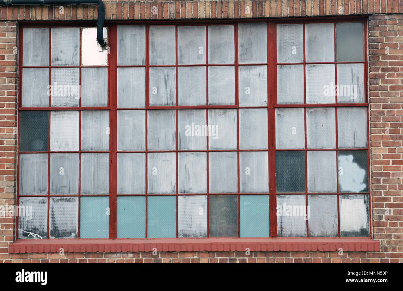 Old windows on a run-down industrial building in the Warehouse District in New Orleans Stock Photo