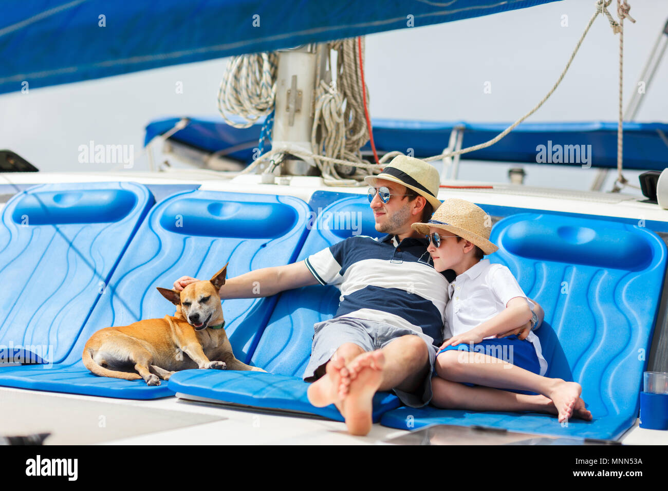 Father, son and their pet dog sailing on a luxury yacht or catamaran