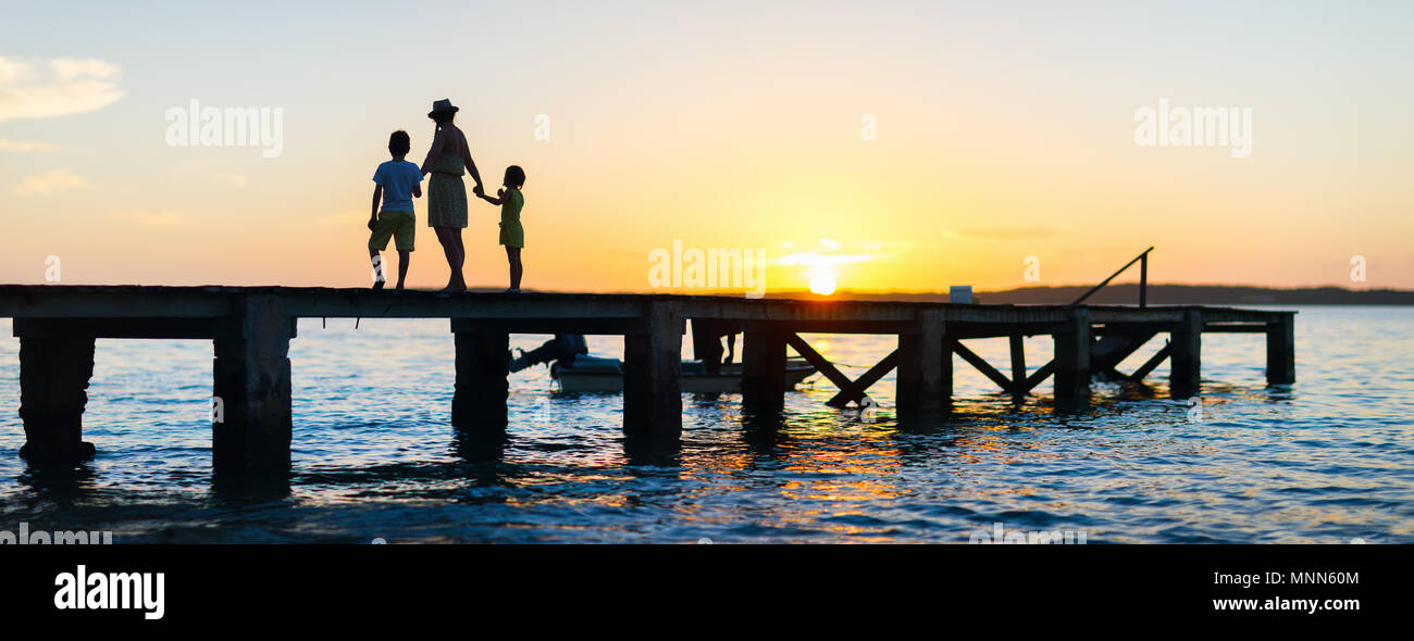 Family silhouettes on a bridge during sunset, Stitched Panorama Stock ...
