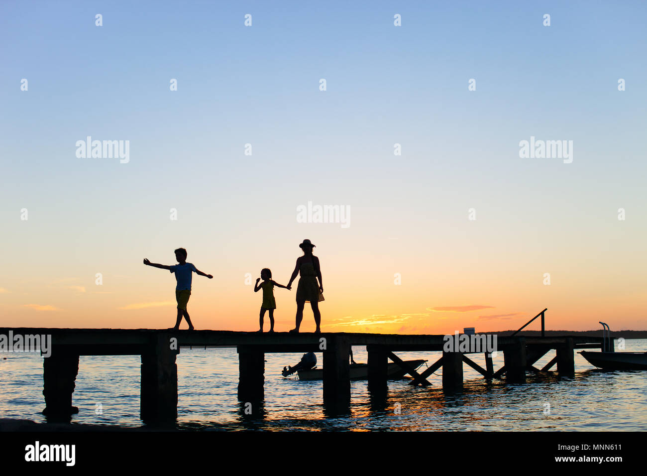 Family silhouettes on a bridge at sunset Stock Photo - Alamy