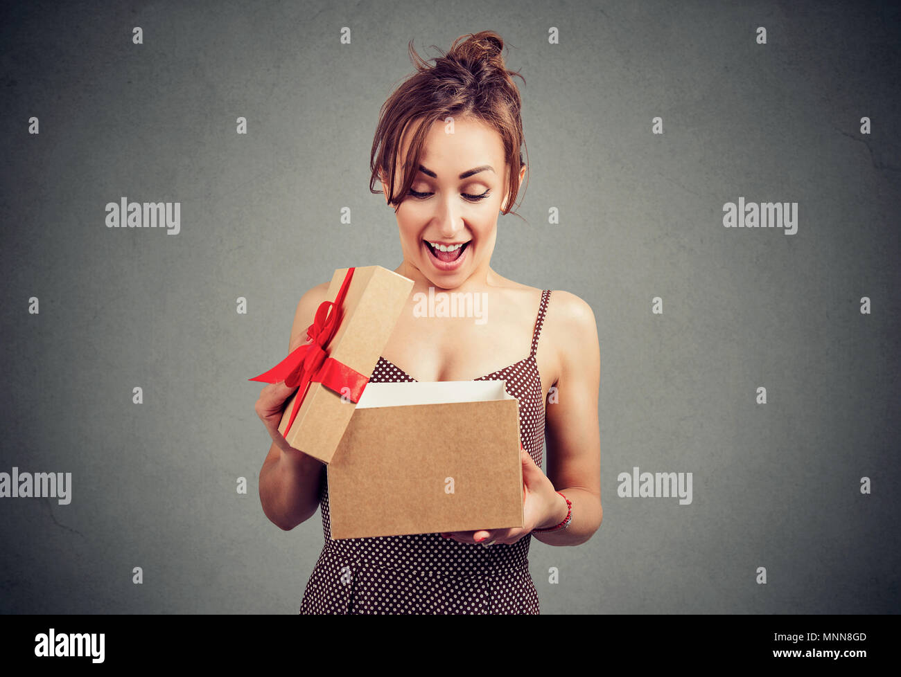 Beautiful young woman opening a gift box with a great present Stock Photo