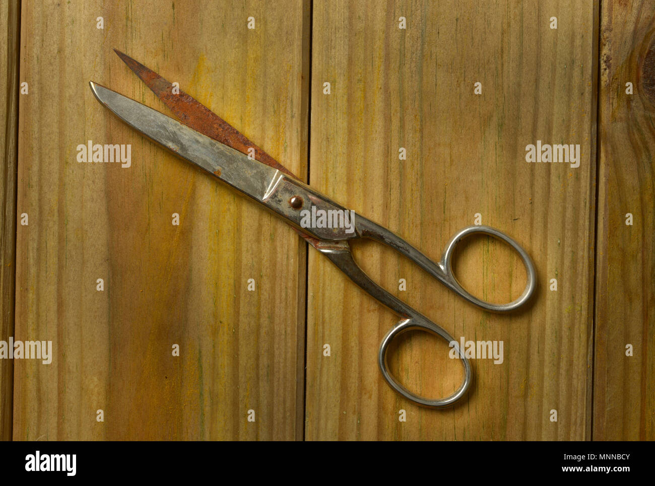 old scissors isolated on wooden background - closeup Stock Photo