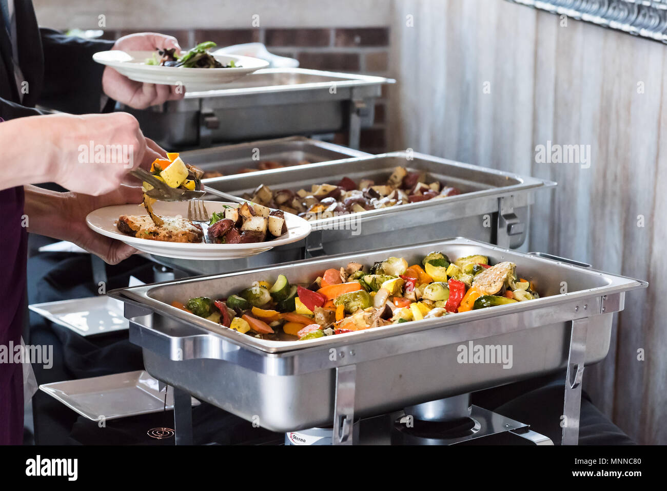 Hot buffet tray, fresh grilled vegetables with closeup of woman using