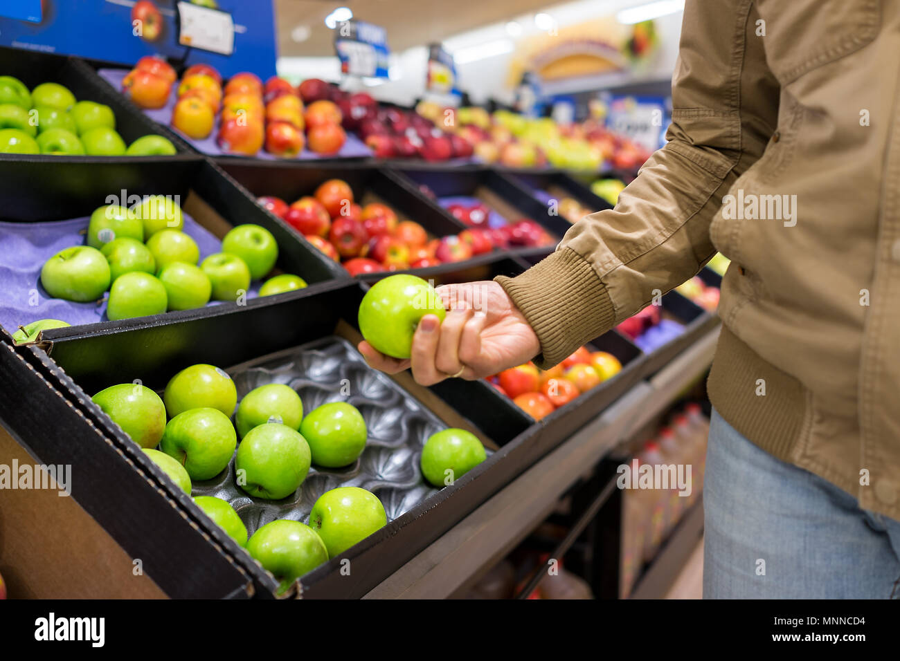 Many varieties assorted apples on display shelf in grocery store boxes