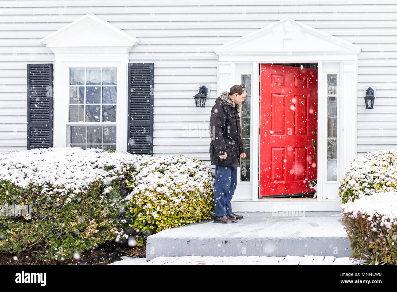 Young Man Outside Front Yard Red Door Of House With Snow