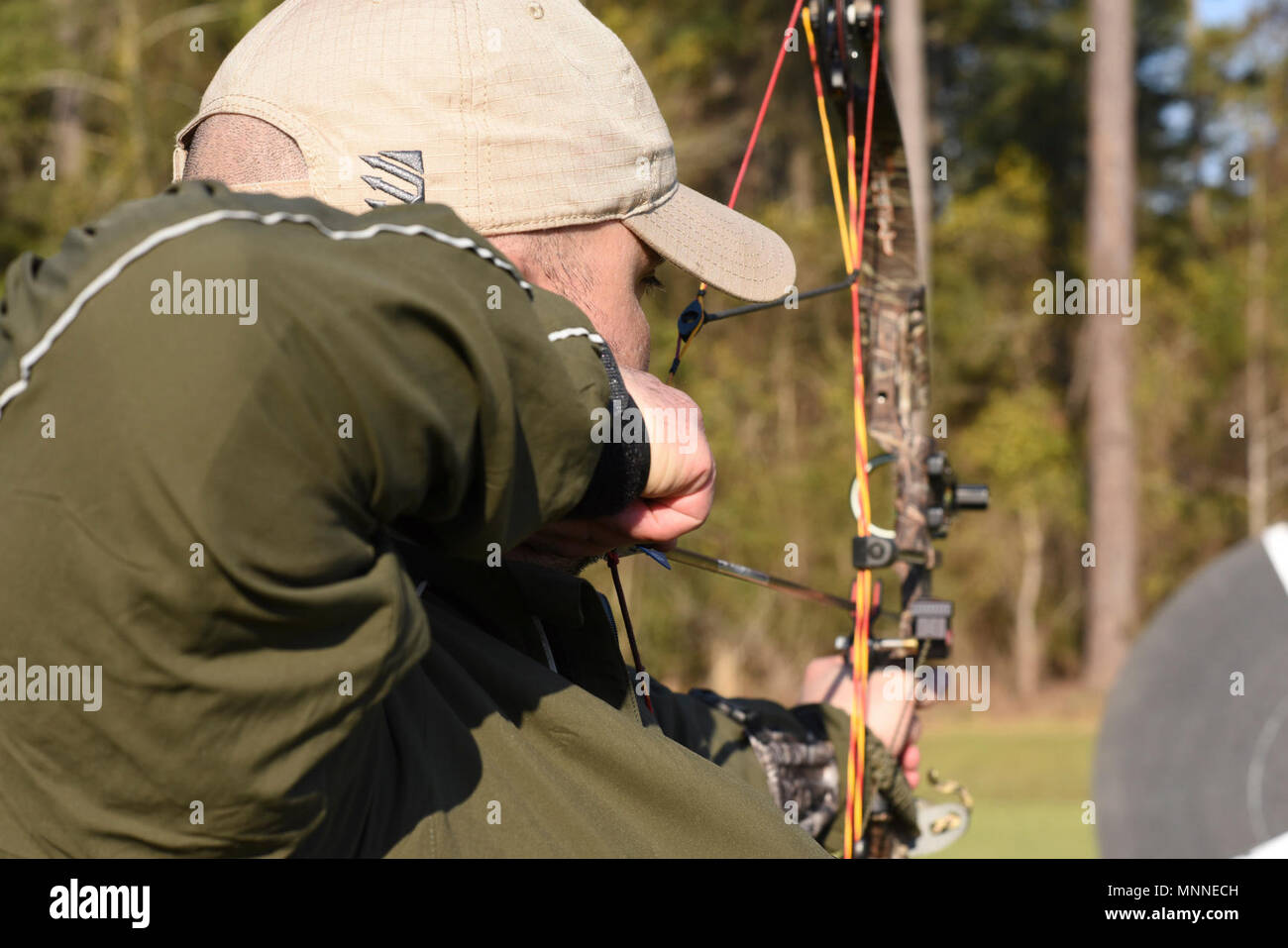 A 2018 Marine Corps Trials athlete draws his bow during an archery practice at Marine Corps Base Camp Lejeune, N.C., March 16, 2018. The Marine Corps Trials promotes recovery and rehabilitation through adaptive sport participation and develops camaraderie among recovering service members (RSMs) and veterans. It is an opportunity for RSMs to demonstrate their achievements and serves as the primary venue to select Marine Corps participants for the DoD Warrior Games. Stock Photo