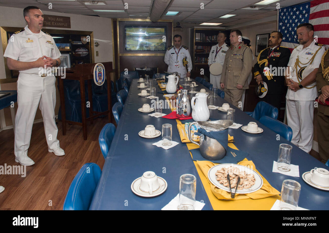 DOHA, Qatar (March 11, 2018) Cmdr. Timothy D. LaBenz, commanding officer of the Arleigh Burke-class guided-missile destroyer USS Sampson (DDG 102), shakes hands with Maj. Gen. Abdulla bin Hassan Al Sulaiti, Commander of the Qatar Emiri Naval Forces inside the Sampson’s wardroom during the Doha International Maritime Defense Exhibition and Conference. Sampson is deployed with the Theodore Roosevelt Carrier Strike Group to the U.S. 5th Fleet area of operations in support of maritime operations to reassure allies and partners and preserve the freedom of navigation and the free flow of commerce in Stock Photo